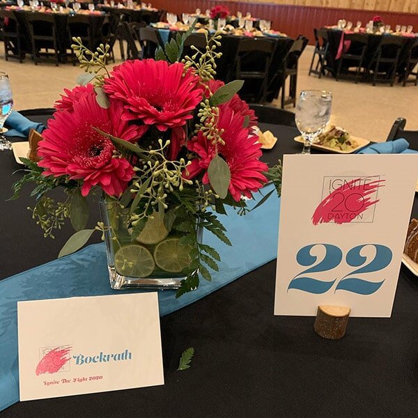 Sponsored fundraiser table with red floral centerpiece in Dayton OH