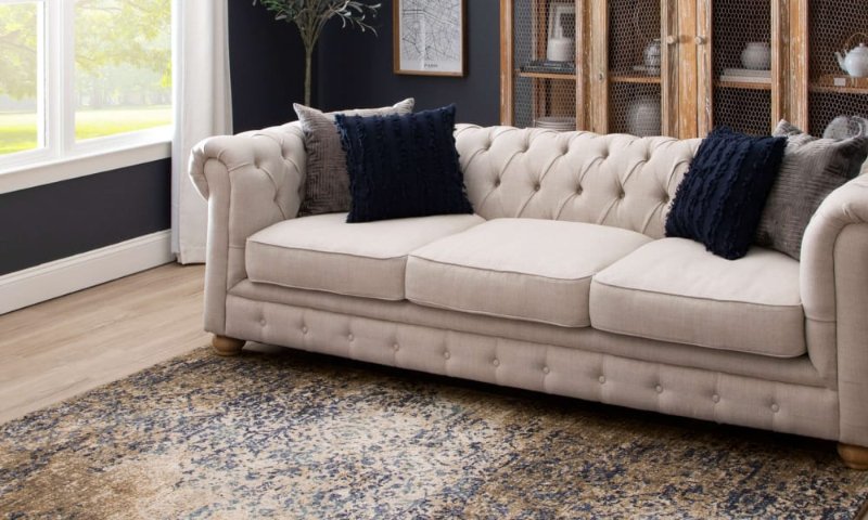 Stylish distressed area rug under a traditional sofa