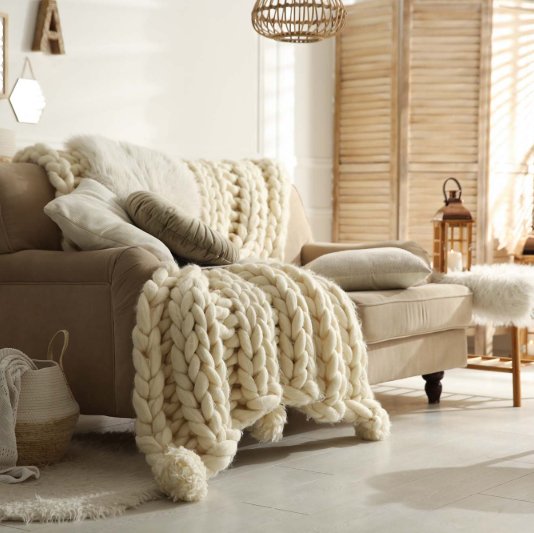 Cozy seating area with a warm blanket on a sofa